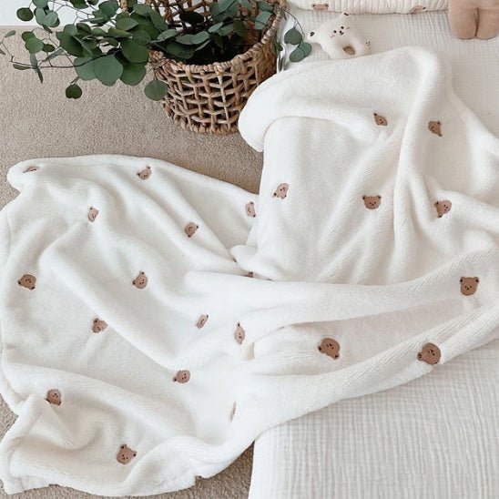 couverture bébé jeté par terre ourson