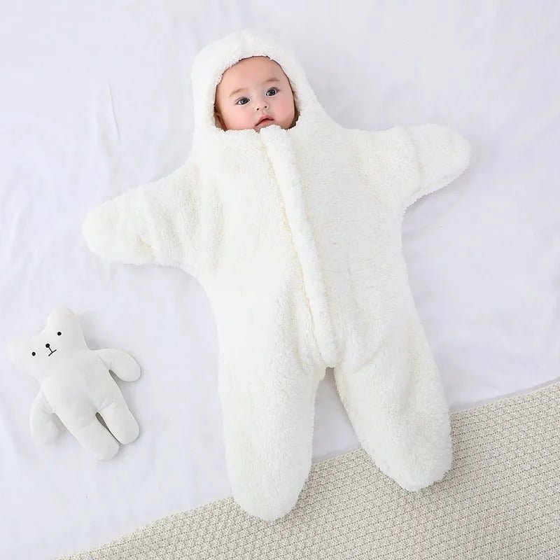 bébé couché dans nid dange bebe enveloppante blanc étoile