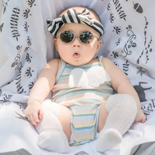 lunette de soleil bebe porté par bébé assis confortablement ovale